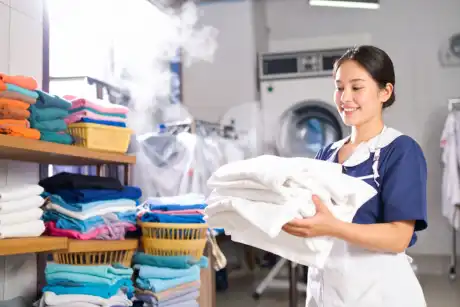 woman holding clean laundry at home – CleanCouture LLC